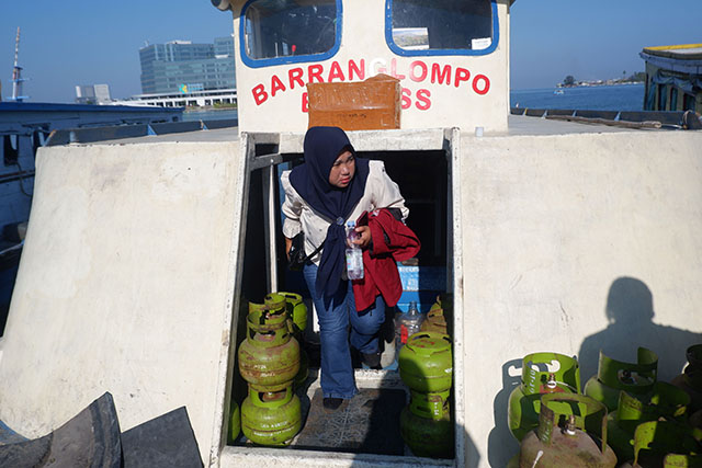 Seorang penumpang turun dari kapal rakyat di Dermaga Kayu Bangkoa.