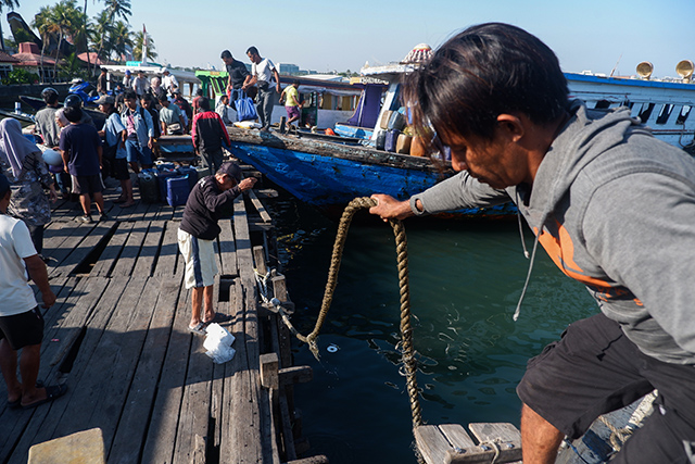 Awak kapal menambatkan kapal rakyat di Dermaga Kayu Bangkoa.