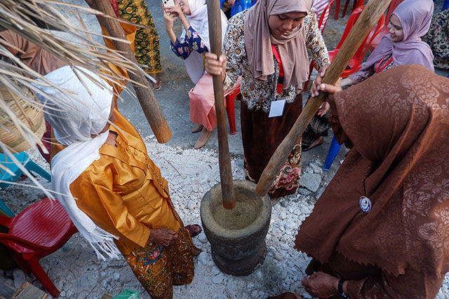 Warga menumbuk bahan pangan menggunakan lesung dan alu secara tradisional dalam Festival Selayar Tempo Doeloe 2026 di Dusun Tajuiya.