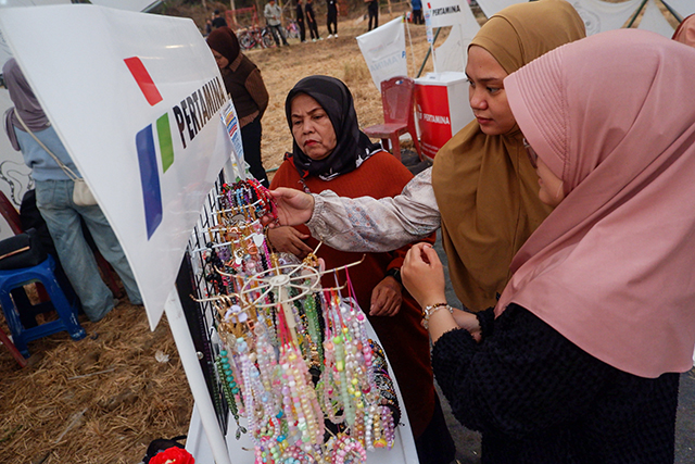 Sejumlah pengunjung melihat dan memilih aksesori berupa gelang serta gantungan hias yang dipamerkan oleh mitra binaan Usaha Mikro dan Kecil (UMK) Pertamina Patra Niaga Regional Sulawesi dalam Festival Mindspace Chapter III bertema Artistic Ecology di Makassar, Sulawesi Selatan, Minggu (25/10/2026).