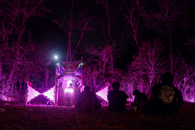 Sejumlah pengunjung menikmati instalasi cahaya artistik di tengah pepohonan dengan perpaduan cahaya berwarna ungu dan alunan musik dalam Festival Mindspace Chapter III bertema Artistic Ecology di Makassar, Sulawesi Selatan, Minggu (25/10/2026).