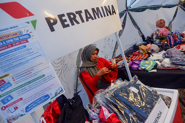 Seorang pelaku usaha mikro dan kecil (UMK) binaan Pertamina Patra Niaga Regional Sulawesi menata produk fesyen yang dipamerkan dalam Festival Mindspace Chapter III bertema Artistic Ecology di Makassar, Sulawesi Selatan, Minggu (25/10/2026).